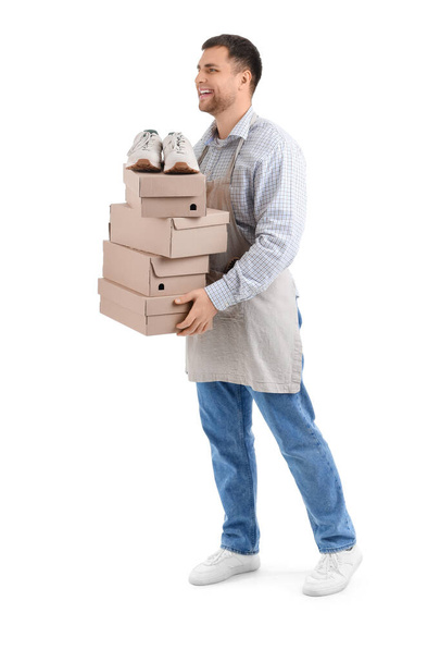 Zapatero masculino con cajas de zapatos sobre fondo blanco - Foto, imagen