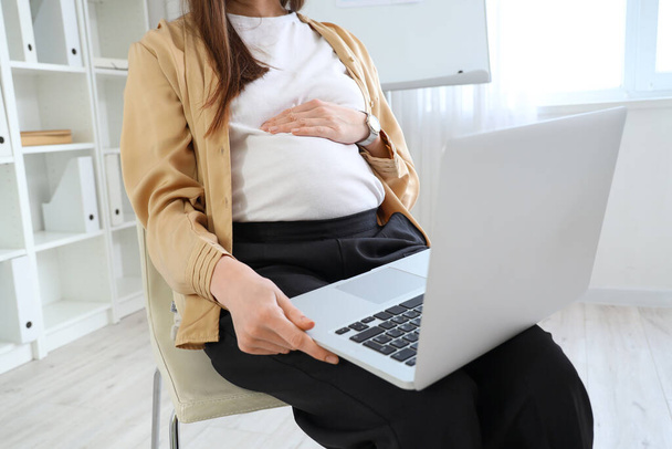 Mulher de negócios grávida bonita com laptop sentado no escritório - Foto, Imagem