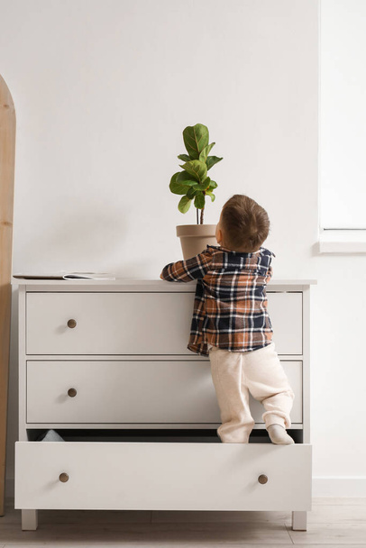 Little boy climbing on commode at home, back view. Child in danger - Photo, Image