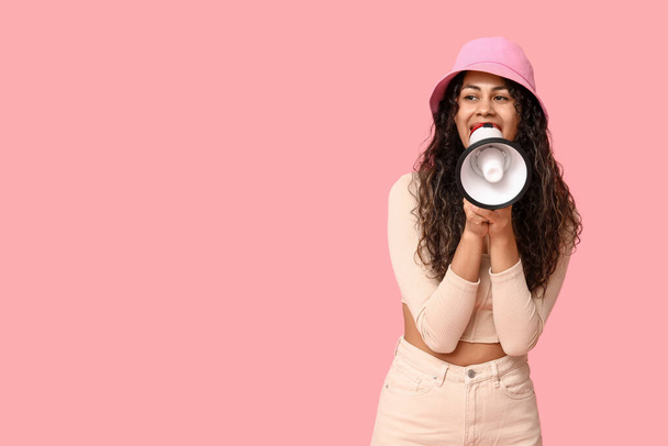 Young African-American woman with megaphone on pink background - Photo, Image