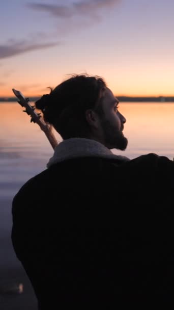 Der bärtige spanische Gitarrist macht ein Selfie mit seiner Gitarre bei Sonnenuntergang am Torrevieja Pink Lake in Alicante, Spanien - Vertikales FullHD-Video - Filmmaterial, Video