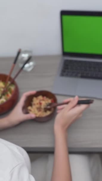 Nad hlavou záběr ženy jíst rýži jídlo, zatímco v přední části svého notebooku. - Svisle - Záběry, video