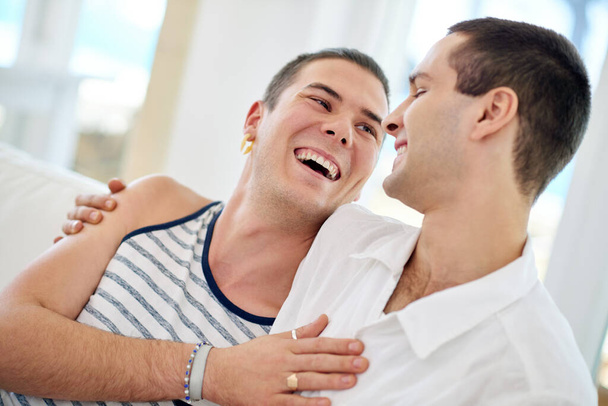 Men, gay and happy couple in home relax with bonding connection or queer pride for homosexual, love or comfort. Male people, embrace and laughing joke in apartment for relationship, marriage or rest. - Φωτογραφία, εικόνα