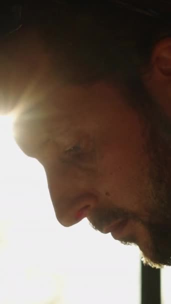 Szakállas és etnikai fülbevalós férfi néz valamit lent - FHD Függőleges videó - Felvétel, videó
