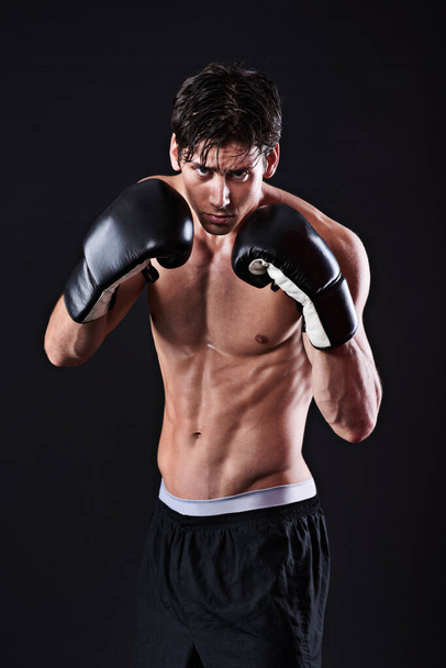 Man, portrait and boxing gloves in studio for exercise fight or martial arts training or performance, black background or gym. Male person, face and self defence fitness for athlete, mockup or punch. - Photo, Image