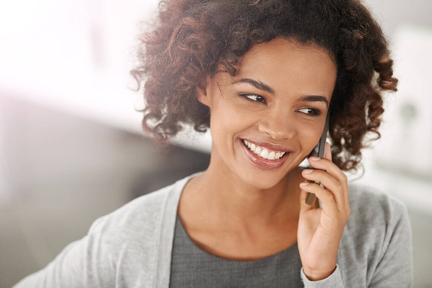 Black woman, satisfied and smartphone for phone call with conversation, communication and mobile in office. Closeup, female person and happy with work break for networking, discussion and connection. - Photo, Image