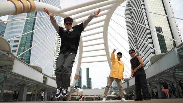 Grupo de dançarino de rua profissional animar-se enquanto hipster asiático executar passo livre na cidade cercada por pessoas com câmera de baixo ângulo. Conceito de dança de pausa. Desporto ao ar livre 2024. Sprightly. - Foto, Imagem