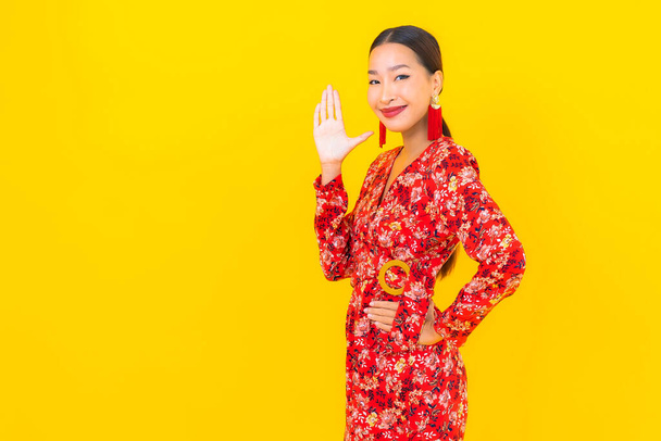Retrato hermosa joven mujer asiática sonrisa en acción en chino nuevo concepto de año en el fondo de color - Foto, imagen