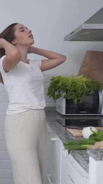 Nainen ruokakassin kanssa purkaa tuoreita vihreitä vihanneksia. Keskikokoinen laukaus - Pystysuora - Materiaali, video