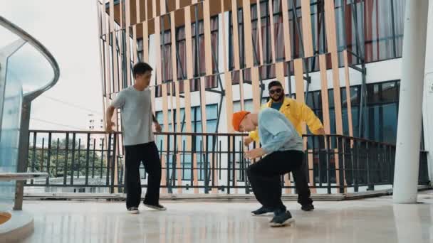 Ομάδα hipster κινείται βήμα προς τη μουσική hip-hop στο εμπορικό κέντρο διάδρομο. Εξειδικευμένη χορεύτρια διάλειμμα εκτελέσει b-boy χορό, ενώ περιβάλλεται από πολυπολιτισμική φίλο ή χορεύτρια ομάδα. Υπαίθριο άθλημα 2024. hiphop. - Πλάνα, βίντεο