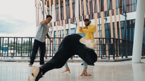 回廊モールのヒップホップ音楽に足跡を移動するヒップスターのグループ. 熟練したブレイクダンサーは,多文化の友人やダンサーグループに囲まれてBボーイダンスを行います. アウトドアスポーツ 2024 ヒップホップ. - 映像、動画