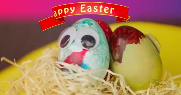 Drei bunte, bemalte glückliche Ostereier rotieren auf dem Bahnsteig | Grafisches Banner über "Frohe Ostern" | 4k Video - Filmmaterial, Video