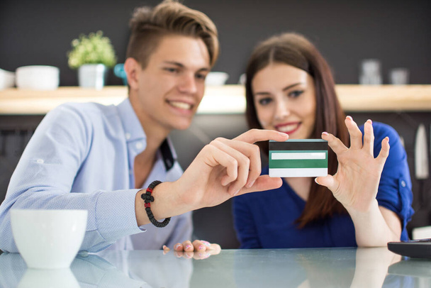 Egy fiatal pár tartja egyben a hitelkártyáját. Koncentrálj a hitelkártyára - Fotó, kép
