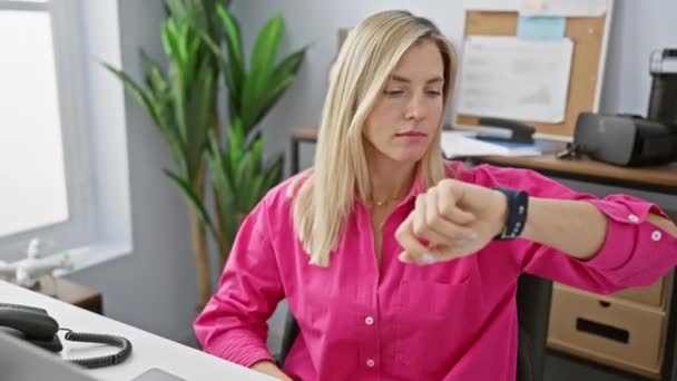 Uma jovem verifica o tempo em seu smartwatch em um ambiente de escritório, exalando profissionalismo e pontualidade. - Filmagem, Vídeo