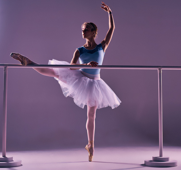 classic ballerina posing at ballet barre - Fotó, kép