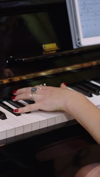 Девушка страстно поет с планшетом перед собой, опираясь на пианино - FHD Вертикальное видео - Кадры, видео