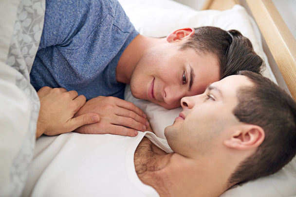 Men, gay and couple or morning in bed for resting with lgbt pride with comfortable love, happiness or connection. Male person, queer and smile with bonding support in home together, calm or peace. - Photo, Image