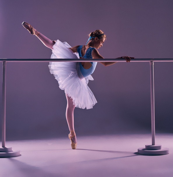 classic ballerina posing at ballet barre - Foto, afbeelding