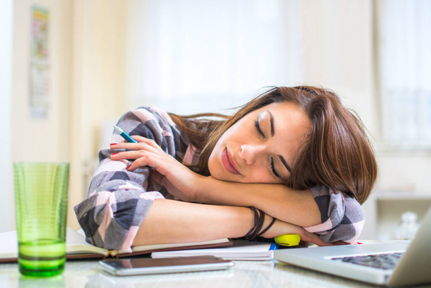 Jeune femme épuisée dormant au bureau - Photo, image