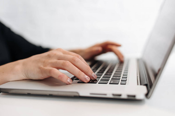 Zamknij kobiecie ręce wpisując klawiaturę na laptopie w biurze. Bizneswoman lub uczennica korzystająca z komputera do marketingu internetowego, freelance, praca w domu, edukacja online, studia na odległość. - Zdjęcie, obraz
