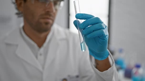 Spaanse wetenschapper met baard onderzoekt reageerbuis in lab. - Video