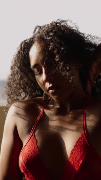 Superbe latina touchant ses cheveux bouclés par la fenêtre - FHD Vidéo verticale - Séquence, vidéo