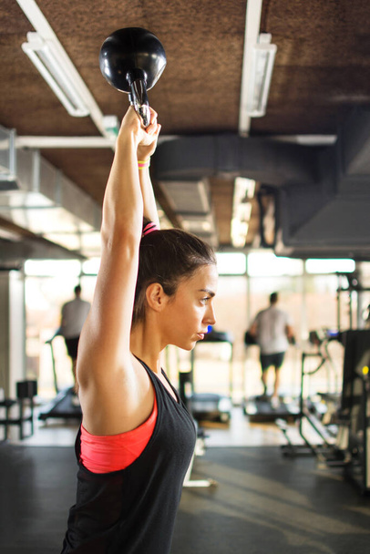 Mujer deportiva haciendo ejercicios con pesas kettlebell en el gimnasio. - Foto, imagen