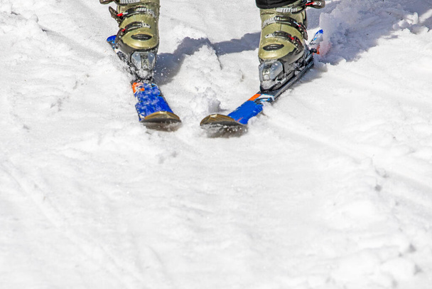 skischoenen met ski 's op een besneeuwde piste. - Foto, afbeelding