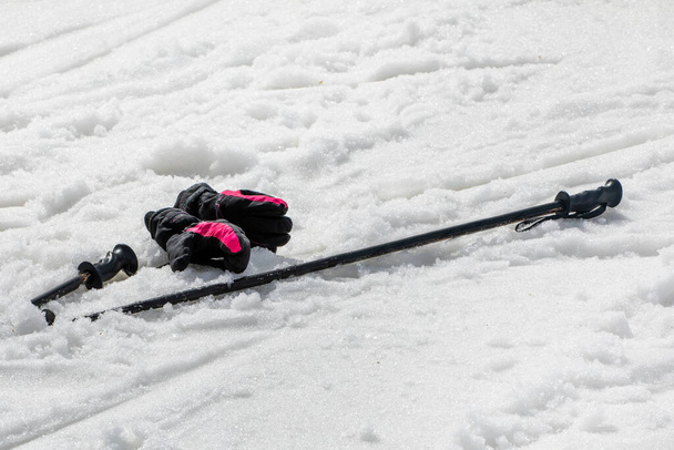 лыжи с перчатками на сыром снегу на склоне в солнечный день. Досуг - Фото, изображение