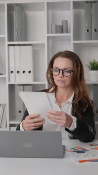 Businesswoman in office carefully analyzing financial reports and revenue growth strategies. Her focus and ability to work with data make her effective in the field of management. High quality FullHD - Materiaali, video