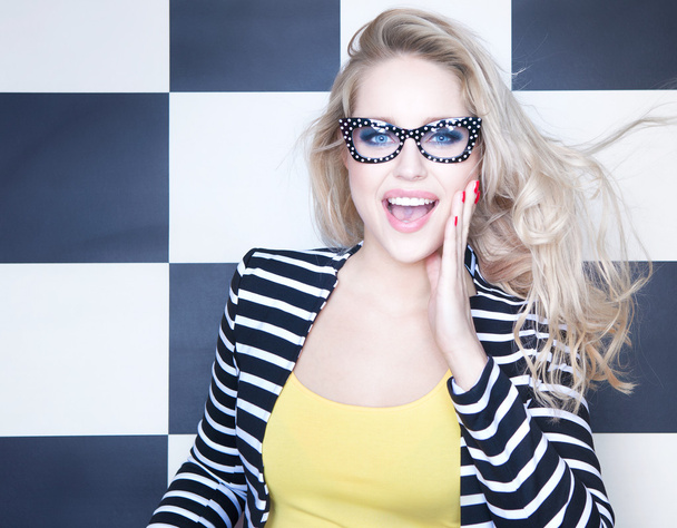 Woman wearing sunglasses on checkered background - Zdjęcie, obraz