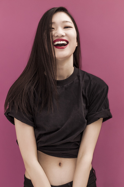 Happy chinese girl portrait on pink background - Foto, Imagen