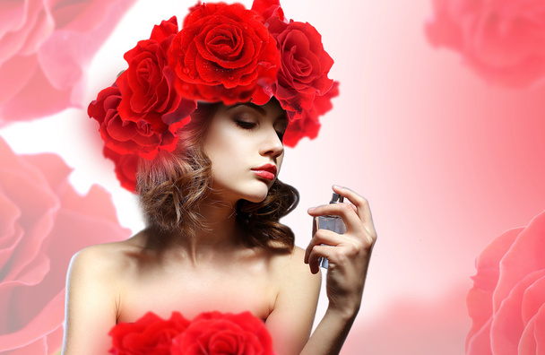 Beautiful woman with perfume bottle in flowers - Foto, Imagen