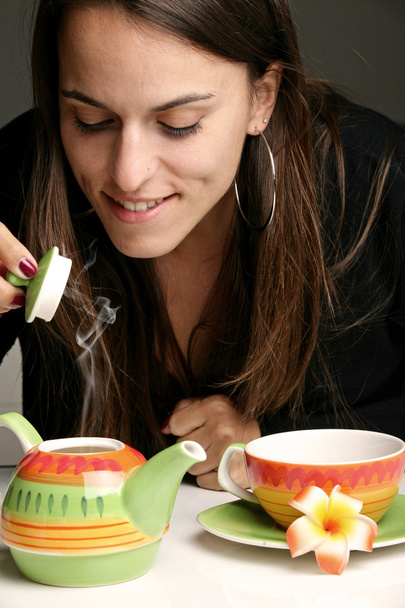 Femme se verser une tasse de thé
 - Photo, image