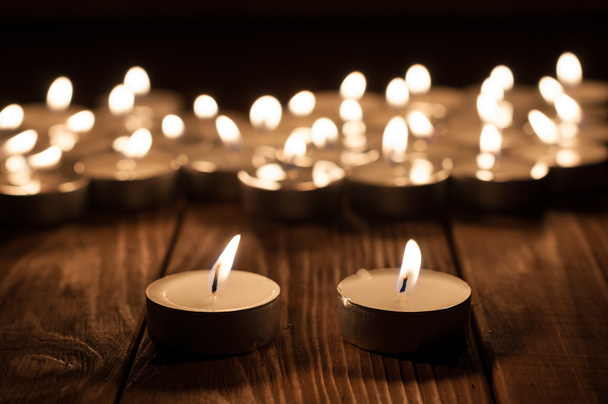 Kilka świec i rozmyte świece na stare drewniane tła - Zdjęcie, obraz