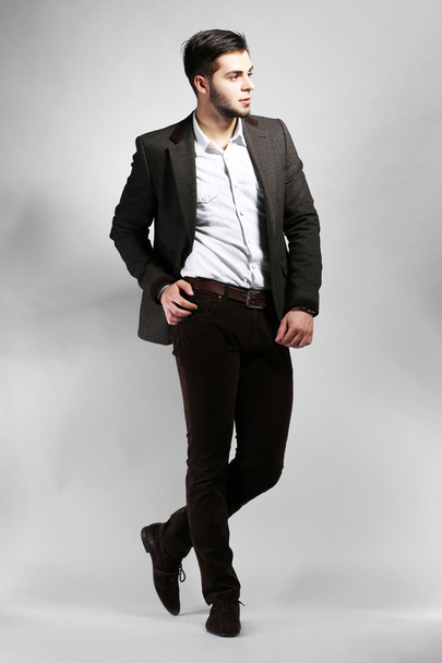 Elegant man in suit on gray background - Фото, зображення