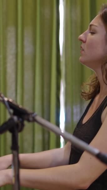 Fiatal kaukázusi lány zongorázik és mosolyog a kamerába - FHD függőleges videó - Felvétel, videó
