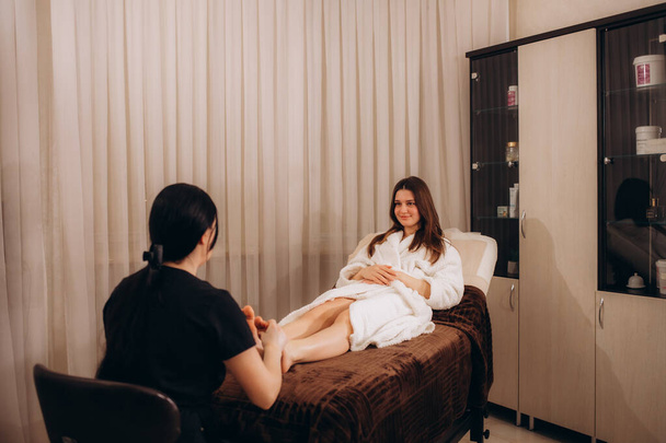 Primo piano di un massaggiatore che massaggia i piedi di un cliente - Foto, immagini