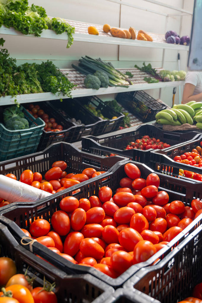 New harvest of fresh ripe red tomatoes in box on farmers market - Foto, Bild