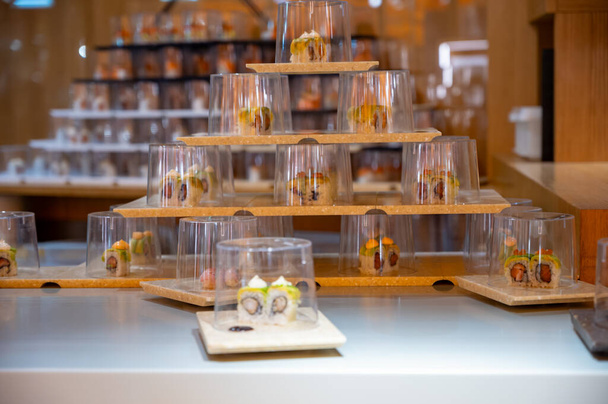 Japanische Küche, modernes Restaurant mit Sushi, Sashimi und anderen japanischen Gerichten, serviert auf einem beweglichen Band quer durch das Restaurant, Selbstbedienungs-Lunch-Café - Foto, Bild