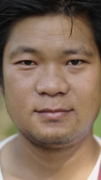 Portré felvétel egy ázsiai férfi bámul a kamera mosolygós - FHD függőleges videó - Felvétel, videó