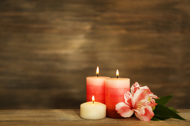 Beautiful composition with candles and spa stones on wooden background - Фото, зображення