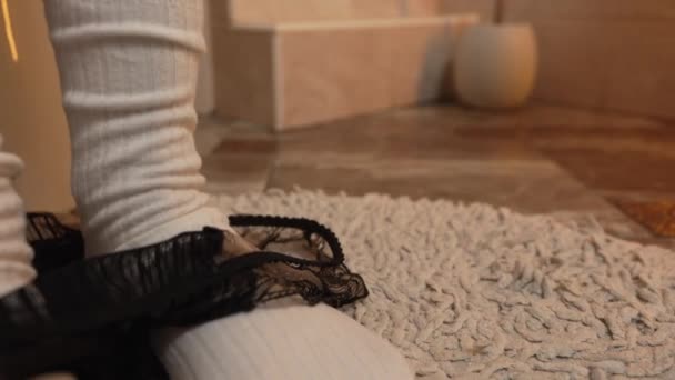 Közelkép lábak meleg fehér zokniban a WC-ben felveszi a bugyit. - Felvétel, videó