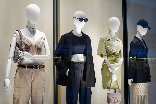 four mannequins in stylish clothes shop window - Photo, Image