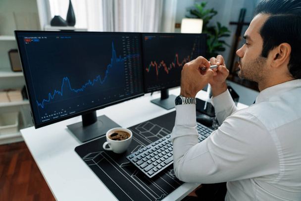 Smart Trader Geschäftsmann Analyse in zwei dynamischen Börse Investition Bildschirm am PC mit Investitionen höchst profitable Finanztechnologie bei der Suche Markt im modernen Home Office. Vermutung. - Foto, Bild