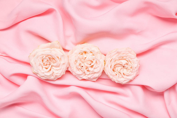 Hermosas flores sobre fondo de tela rosa - Foto, Imagen