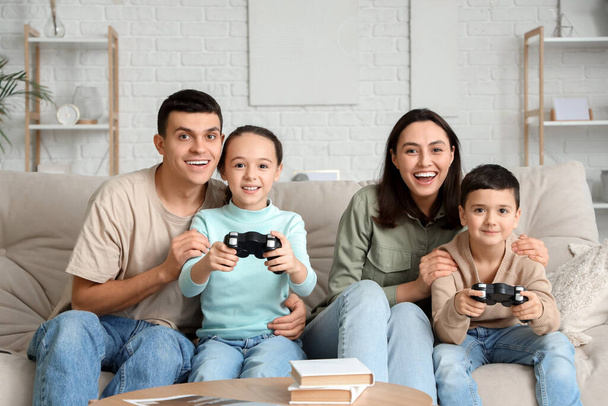 Ευτυχισμένη οικογένεια που παίζει βιντεοπαιχνίδι στον καναπέ στο σπίτι - Φωτογραφία, εικόνα
