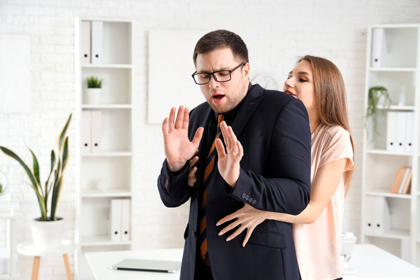 Üzletasszony elcsábítja a férfi kollégáját. A zaklatás fogalma - Fotó, kép