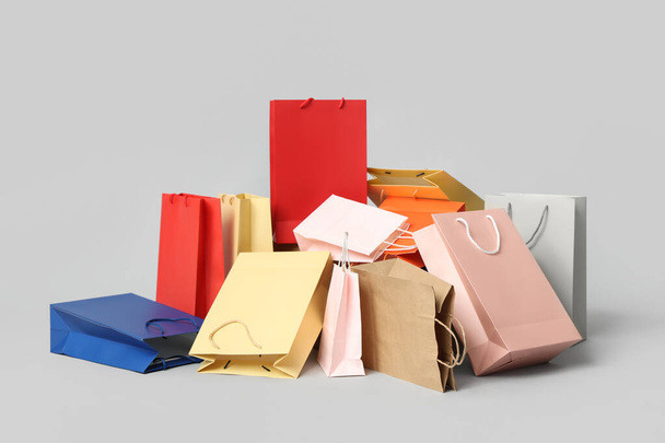 Многие сумки для покупок на сером фоне - Фото, изображение