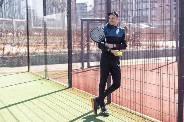 Raket tenis koçu, konutun ön tarafında bir raket kortunda öğretmenlik yapıyor. Yüksek kalite fotoğraf - Fotoğraf, Görsel